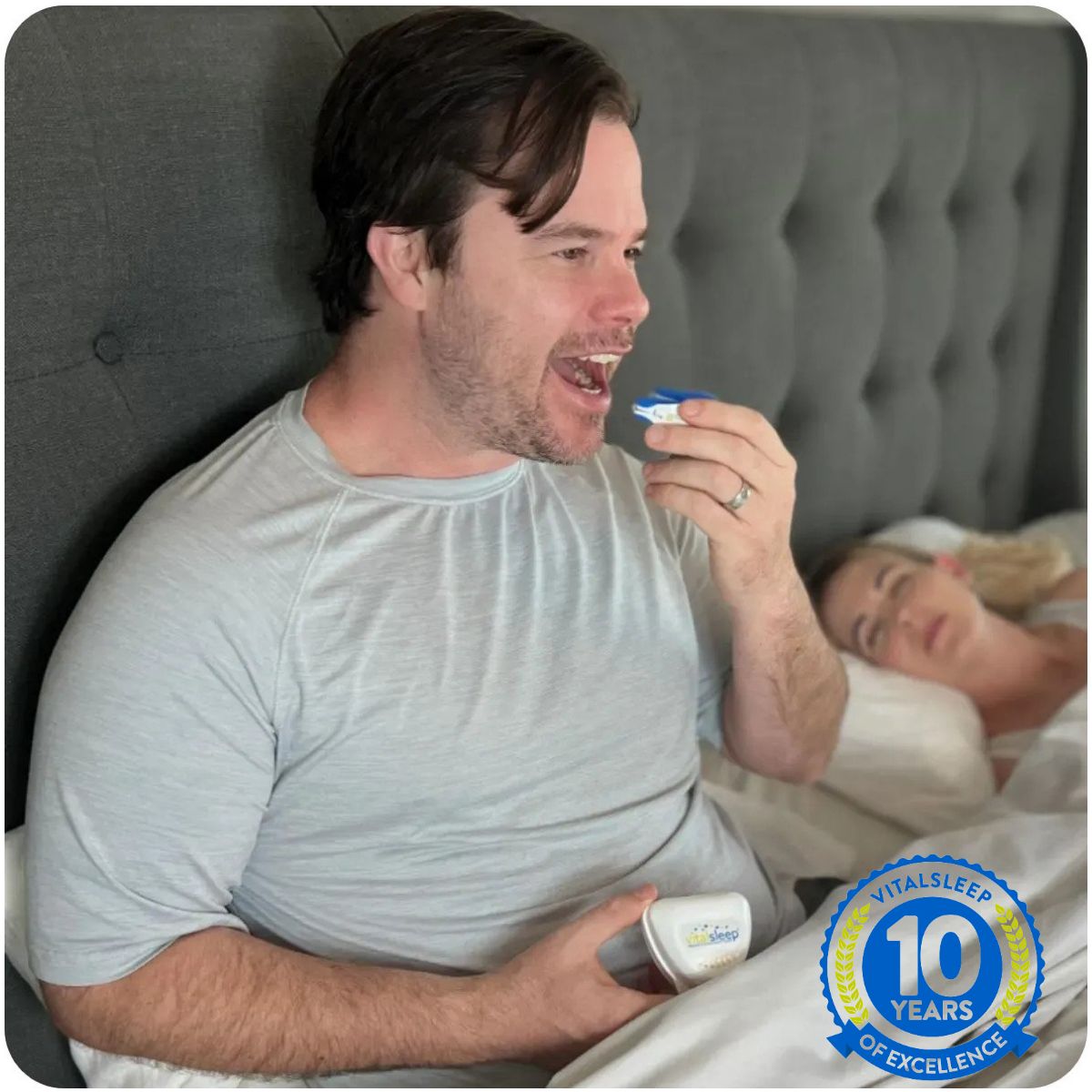 man using snoring mouthpiece in bed